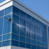 Drone limpando a fachada de vidro de um prédio