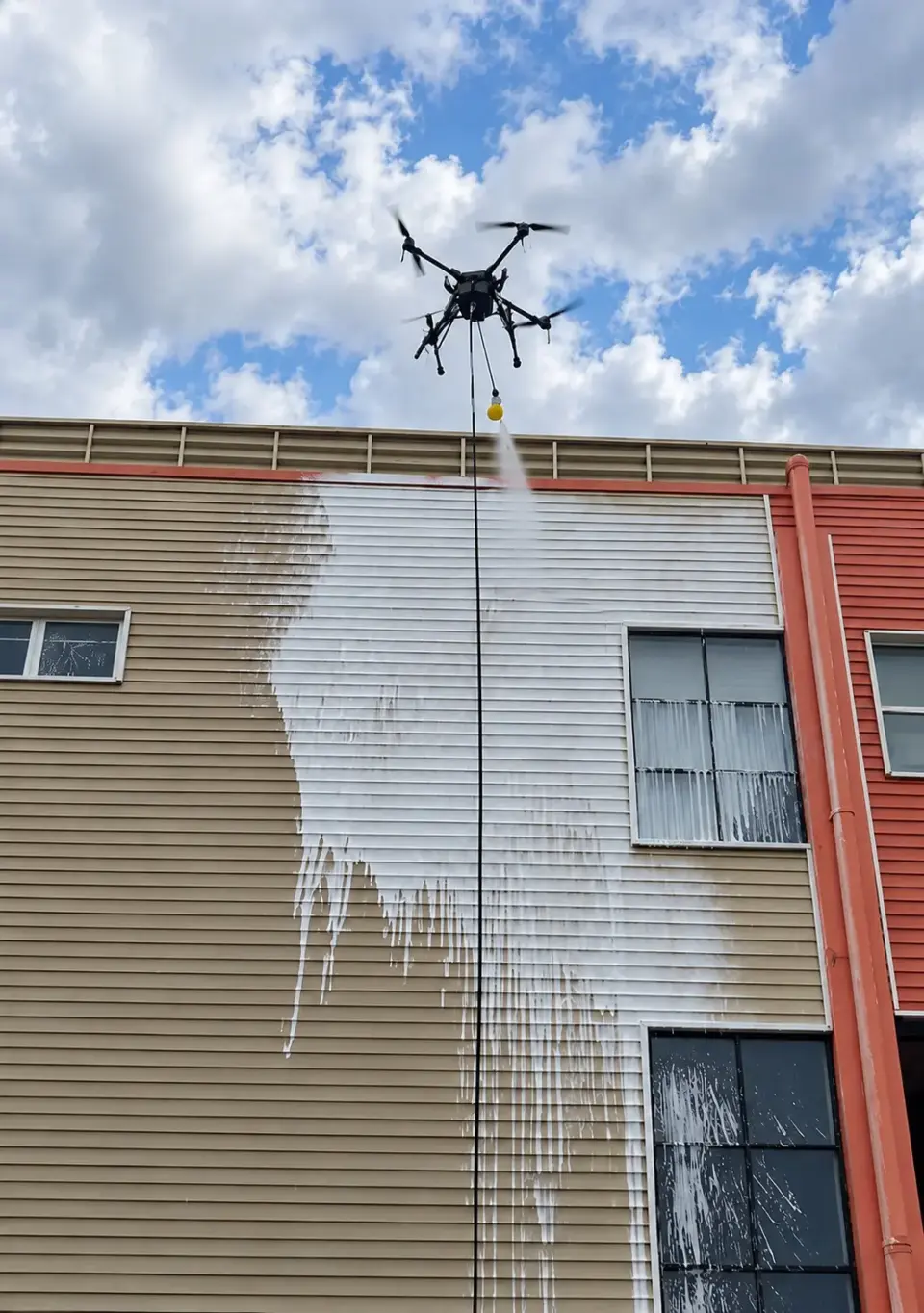 Fachada do galpão industrial com área tratada pelo drone de limpeza