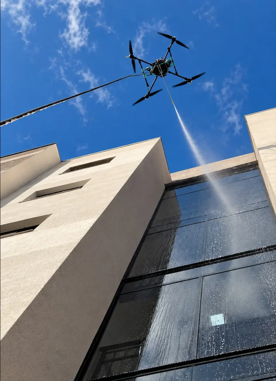 Drone limpando a fachada de vidro de um edifício residencial em Poços de Caldas